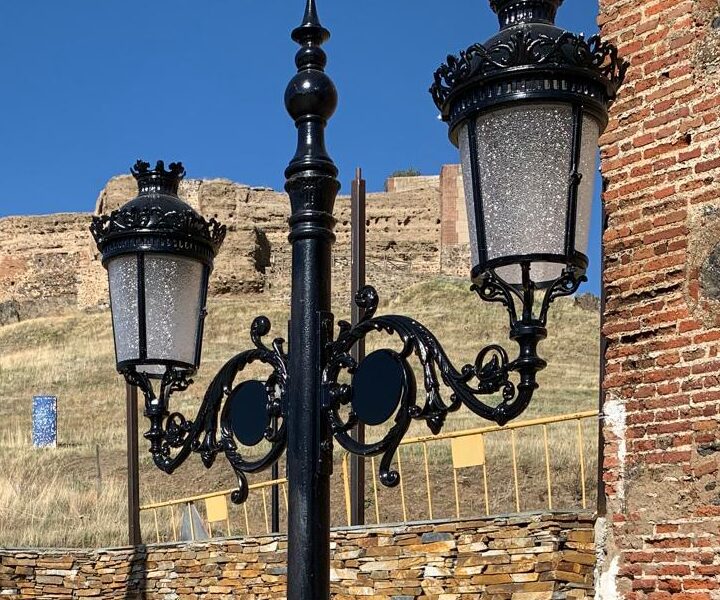 Farola Villa de hierro fundido instalada en entorno histórico con castillo al fondo