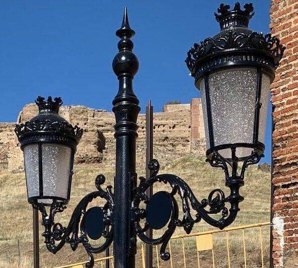 Farola Villa de hierro fundido instalada en entorno histórico con castillo al fondo