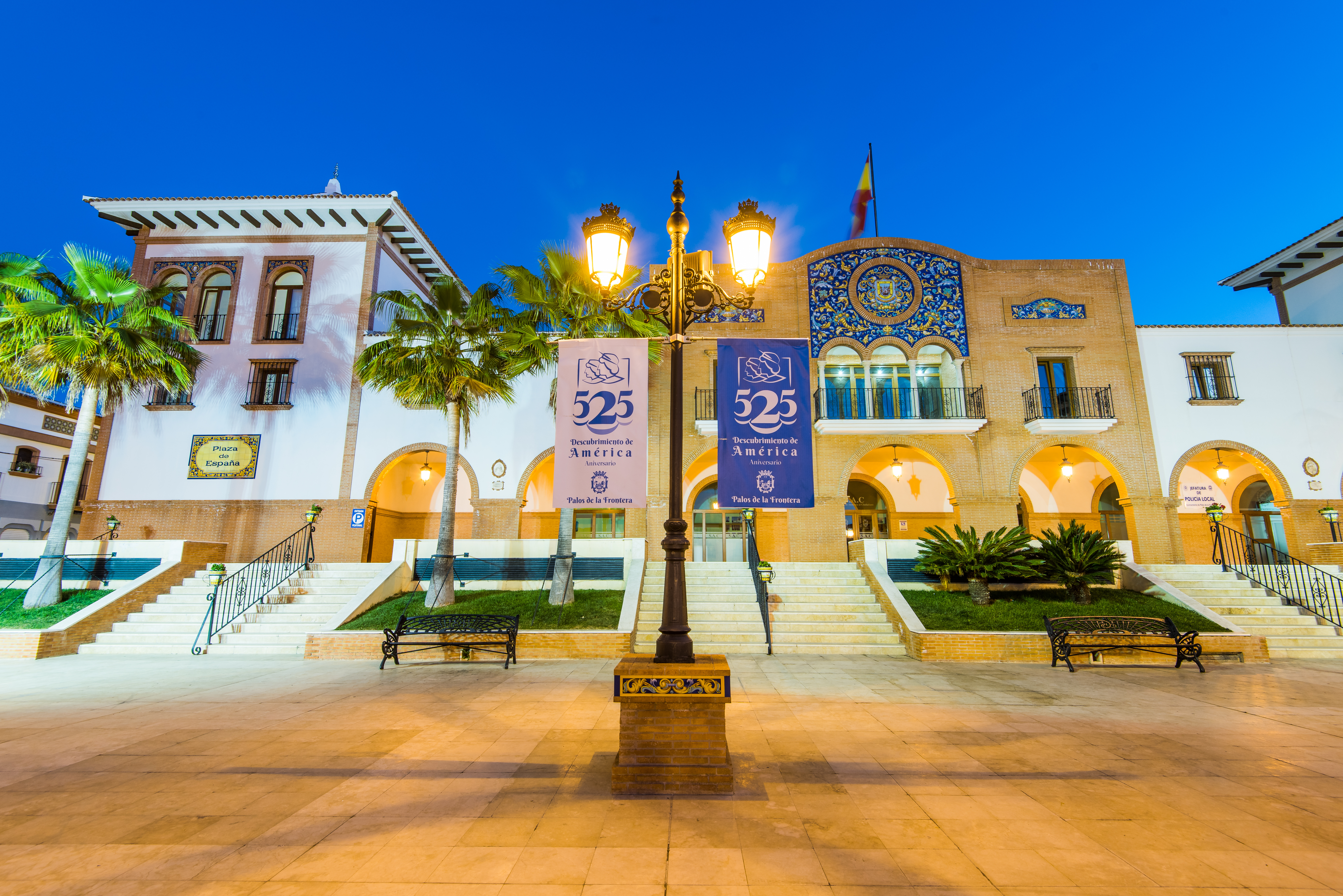 Farola clásica tipo Villa iluminando una plaza histórica española durante la noche