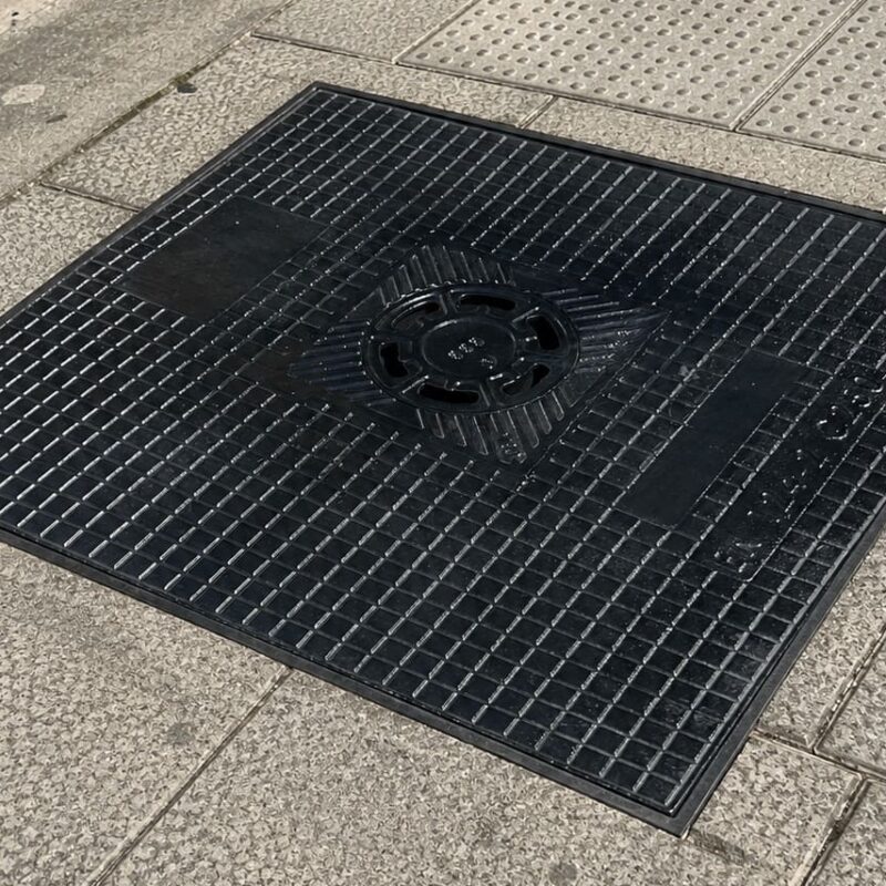 Tapa de arqueta de fundición dúctil instalada en acera urbana